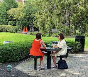 Women sitting on table against trees