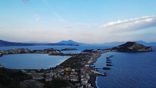 High angle view of city by sea against sky