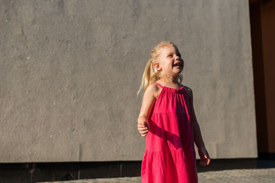 Young woman standing against wall