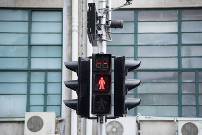 Close-up of road sign against modern building in city