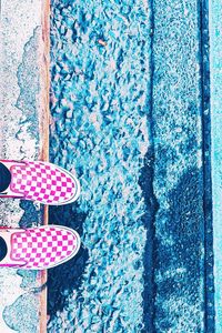 High angle view of pink shoes by swimming pool against wall