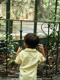 Side view of boy looking through window