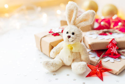 Christmas and new year present with toy plush rabbit and decorations. holiday background.