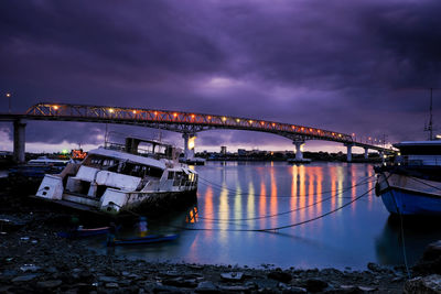 Bridge over river against sky at dusk