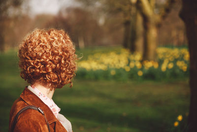 Rear view of woman standing on field