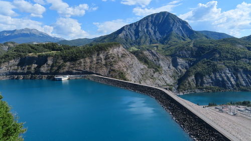 Scenic view of lake by mountains against sky