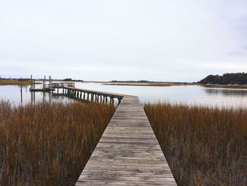 Pier over lake against sky