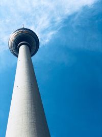 Low angle view of communications tower against blue sky