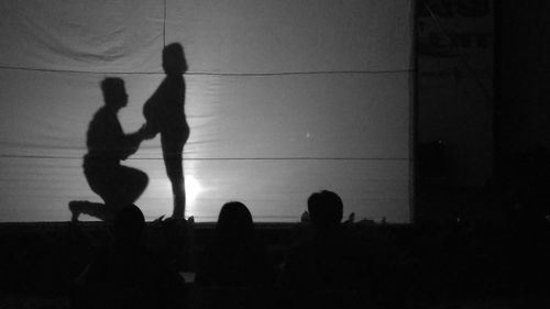 Silhouette people sitting against sky