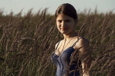 Portrait of smiling young woman standing on field