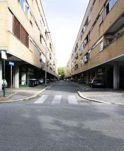 Road amidst buildings against sky in city