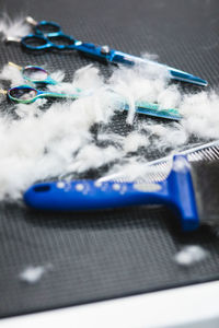 From above of fluffy canine fur near blue scissors and metal comb on grooming table in salon