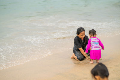 Sisters playing with sand at beach