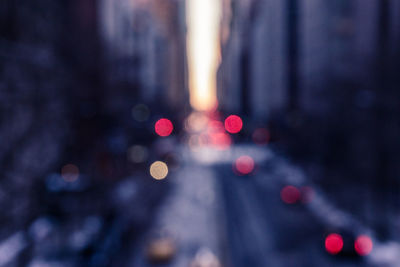 Defocused image of lights on street amidst buildings