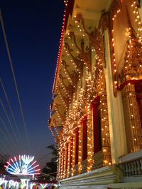 Low angle view of illuminated ferris wheel against sky at night