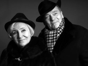 Smiling senior couple against black background