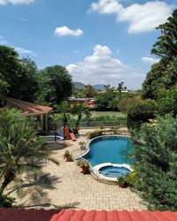 Swimming pool by lake against sky