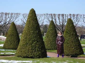 Rear view of woman standing on field against clear sky