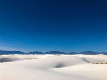 Scenic view of desert against clear blue sky