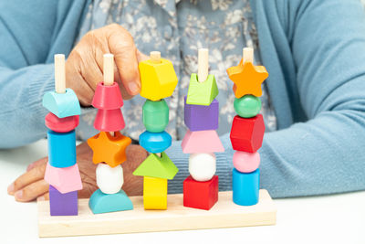 Midsection of man playing with toy blocks on table