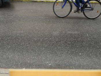 Low section of man riding bicycle on road