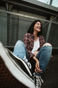 Portrait of a smiling young woman sitting outdoors