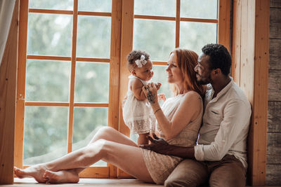 Young couple sitting on window