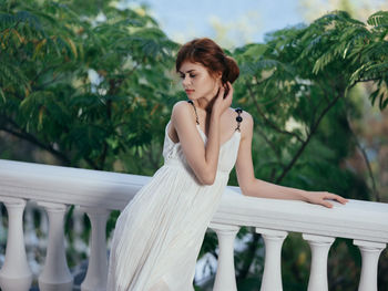 Woman looking away while sitting outdoors