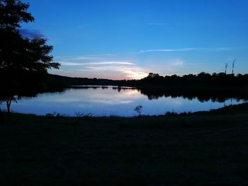 Scenic view of lake against sky at sunset