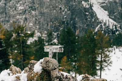 Metal box with hiking stamp on top of mountain peak in winter