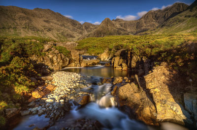 Scenic view of river amidst mountains against sky