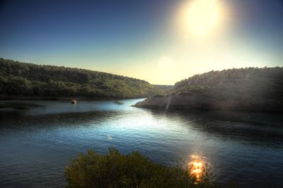 Scenic view of lake by trees against sky