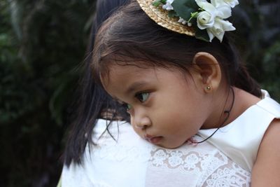 Close-up of cute girl looking away with mother outdoors