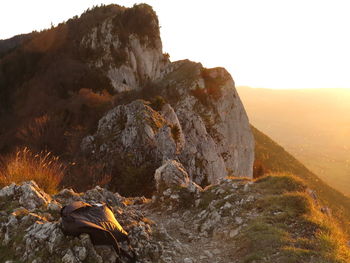 Rock formations on landscape against sky during sunset