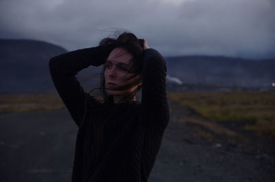 Beautiful woman standing on land against sky