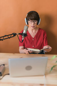 Senior woman broadcasting at studio