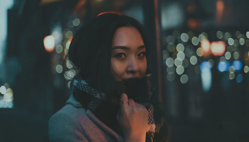 Portrait of young woman looking away at night