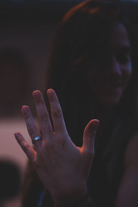 Close-up of smiling young woman showing wedding ring while standing outdoors at night