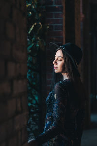 Side view of young woman looking away outdoors