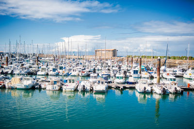 Boats moored in harbor against buildings in city