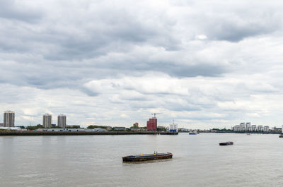 Scenic view of sea by buildings against sky