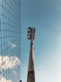 Low angle view of floodlight by net against sky