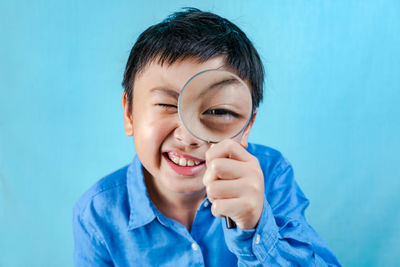 Portrait of smiling boy against blue background