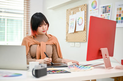 Portrait of young woman using laptop at table