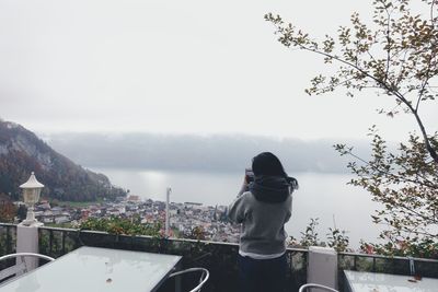 Rear view of man looking at view of mountain against sky