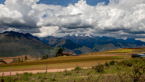 Scenic view of field and mountains against sky