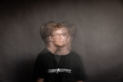 Portrait of boy standing against wall