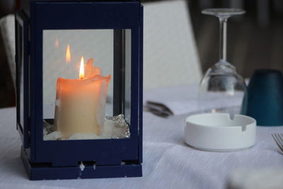 Close-up of lit candle on table