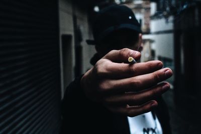 Close-up of man holding cigarette