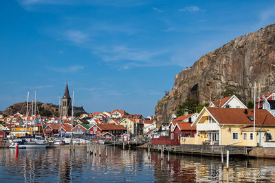 Sailboats moored on canal by buildings in city against sky